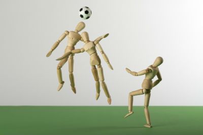 figures playing soccer with the ball on their head